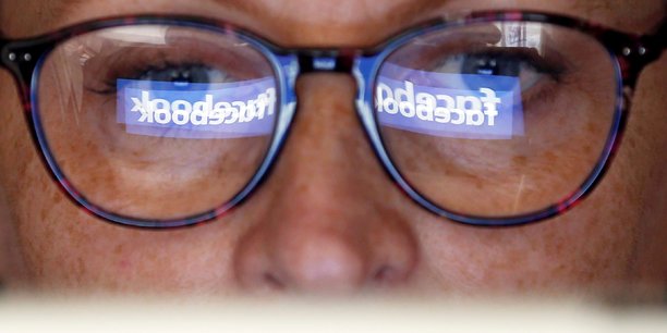 Reflets de logos Facebook dans les lunettes d'une personne agée - Crédit photo : Régis Duvignau - REUTERS